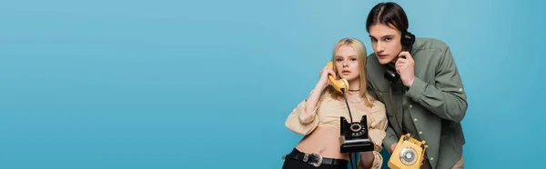 Stylish models talking on telephones on blue background, banner — Stockfoto