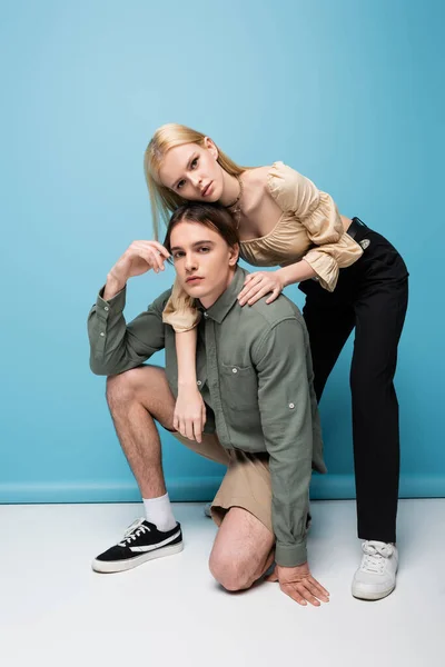 Stylish young models looking at camera on blue background — Foto stock