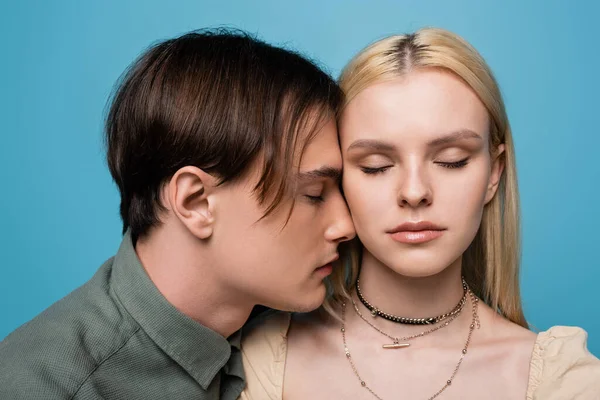 Junges Paar mit geschlossenen Augen steht isoliert auf blauem Grund — Stockfoto
