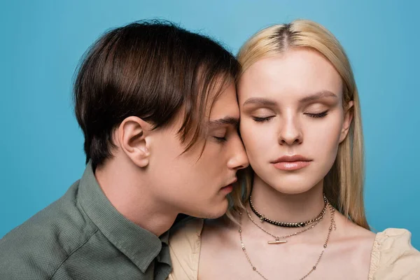 Young couple with closed eyes standing isolated on blue — Stockfoto