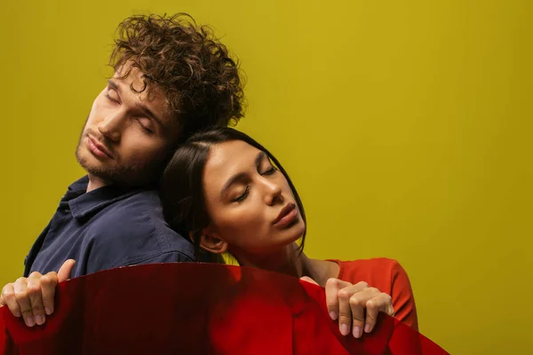 Trendy and young models with closed eyes near round shape glass isolated on green — Photo de stock