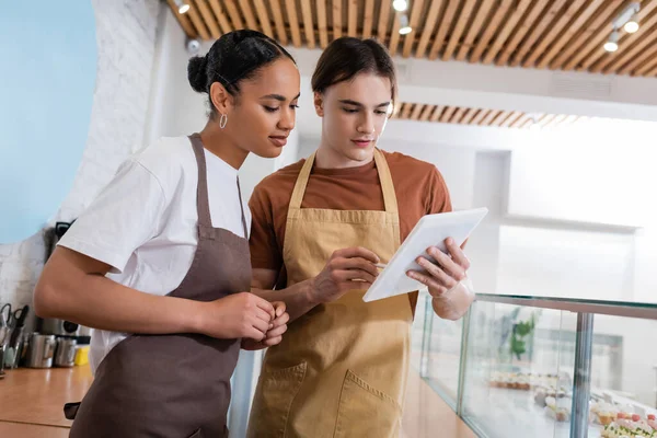 Multiethnische Verkäufer mit digitalem Tablet in Süßwarenladen — Stockfoto