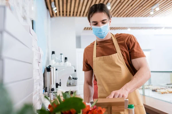 Seller in medical mask using digital tablet in confectionery — Fotografia de Stock