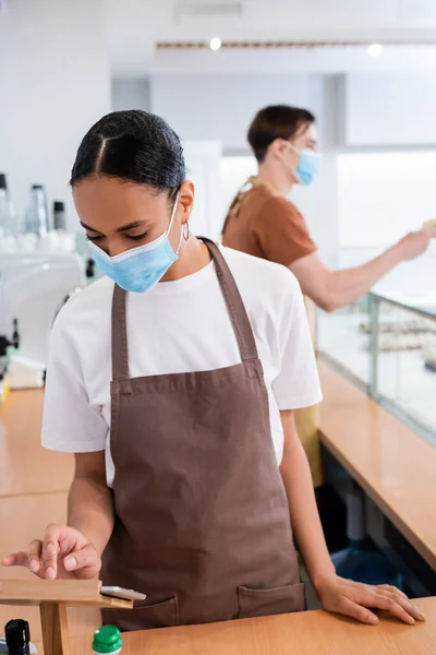 African american saleswoman in medical mask using digital tablet in sweet shop — Stock Photo