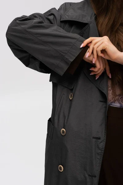 Cropped view of model adjusting organic sleeve on trench coat isolated on grey — Stock Photo