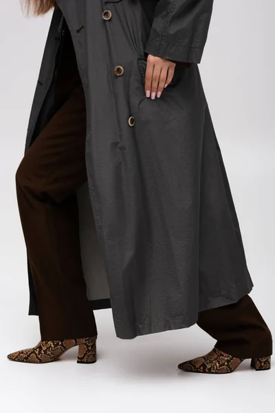 Cropped view of model in stylish trench coat posing on grey — Fotografia de Stock