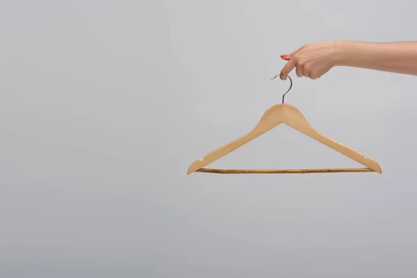 Partial view of model holding wooden hanger isolated on gray — Stockfoto