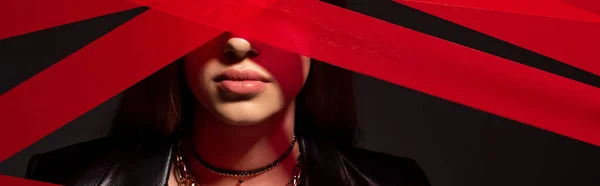 Red strips from duct tape near teenage model isolated on black, banner — Fotografia de Stock