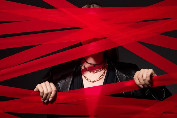 Обрезанная модель касаясь красные полоски из клейкой ленты изолированы на черном, вторичной концепции моды — стоковое фото