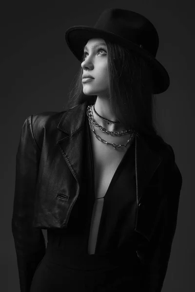 Monochrome photo of teenage model in fedora hat posing in studio — Stockfoto