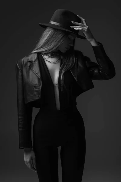 Monochrome photo of teenage model adjusting fedora hat in studio — Foto stock