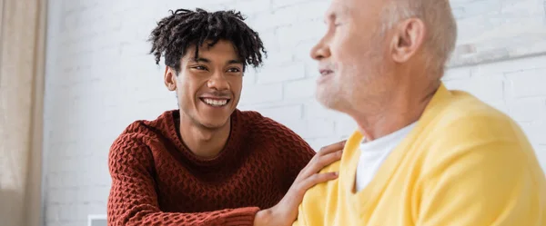 Positive african american man hugging blurred grandparent at hoe, banner — Foto stock