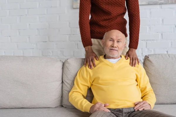 African american man hugging granddad on couch at home — Foto stock