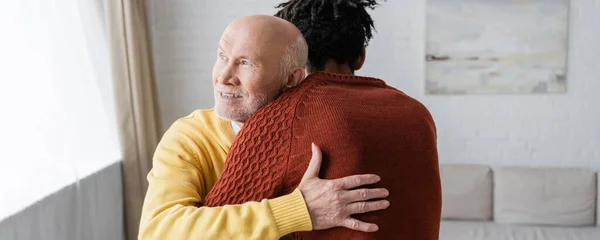 Positive grandparent hugging african american grandson at home, banner — Photo de stock