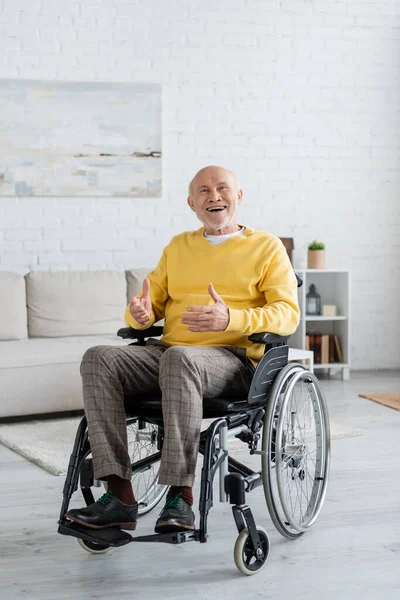 Cheerful senior man sitting in wheelchair at home — Foto stock