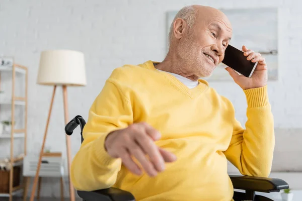 Позитивний старший чоловік розмовляє на смартфоні в інвалідному візку вдома — Stock Photo