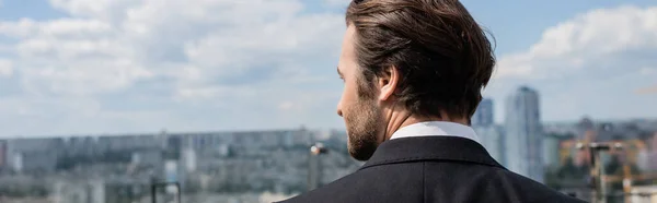 Side view of brunette groom looking away on terrace, banner — Foto stock