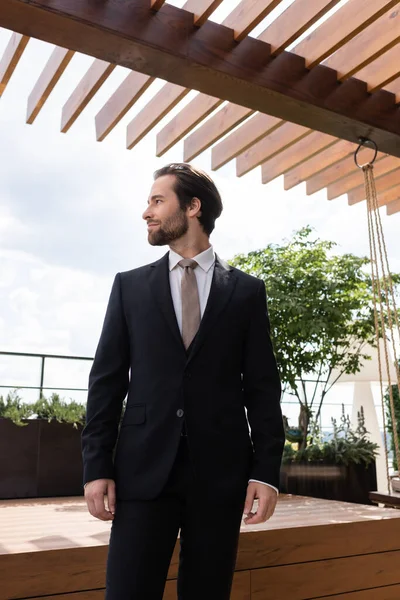 Side view of brunette groom looking away on terrace outdoors — Stock Photo