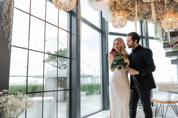 Elegant couple holding roses during date in restaurant — Stock Photo