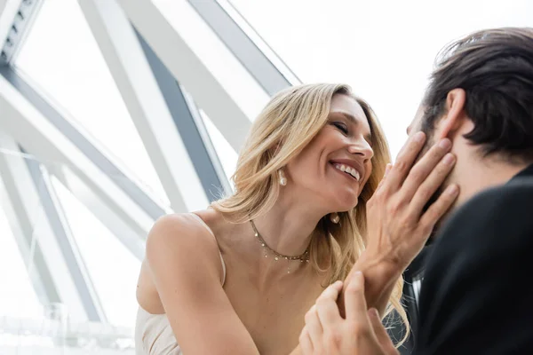 Low angle view of smiling woman touching brunette boyfriend in restaurant — Foto stock