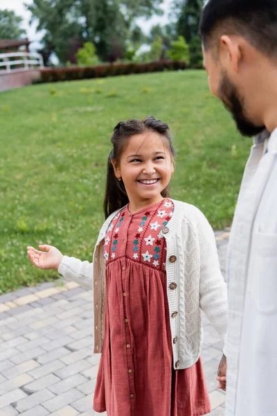 Smiling asian child looking at blurred father in park — Fotografia de Stock