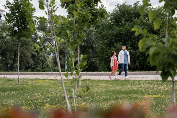 Asian father and daughter walking in summer park — Stockfoto