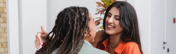 Smiling woman hugging african american girlfriend in cafe, banner — Photo de stock