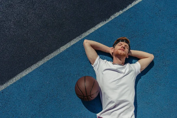Top view of young basketball player relaxing on court near ball — Fotografia de Stock