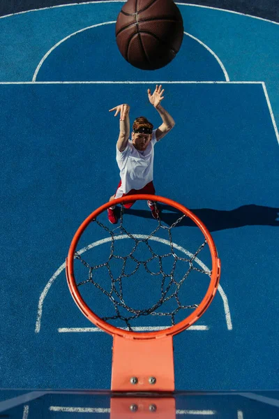 Top view of man throwing ball into basketball hoop — Foto stock