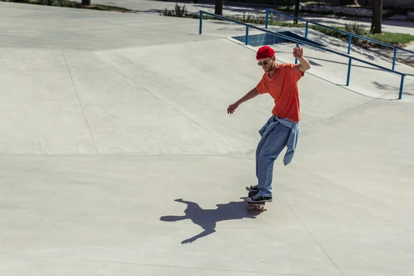 Full length of fashionable young man riding skate outdoors — Stock Photo