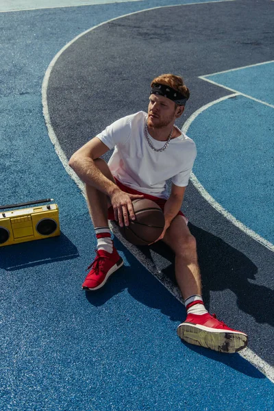 High angle view of sportsman in bandana sitting on court near boombox — Stock Photo