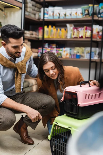 Multiethnic couple choosing animal cage in pet shop — Stock Photo