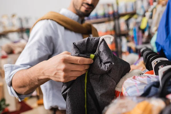 Cropped view of man holding animal jacket in pet shop — Stockfoto