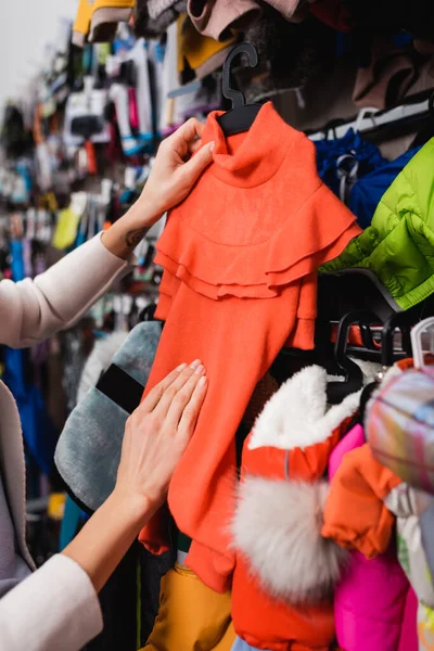 Обрізаний вид жінки, яка вибирає одяг для домашніх тварин в магазині — стокове фото