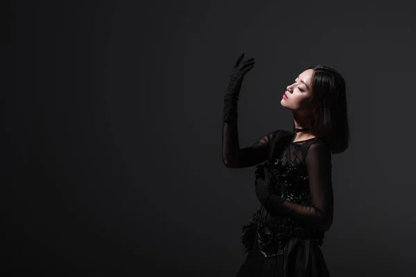 Sensual asian woman in gothic dress gesturing isolated on grey — Stockfoto