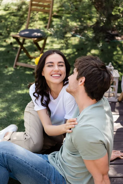 Cheerful woman touching boyfriend on terrace outdoors — Stock Photo