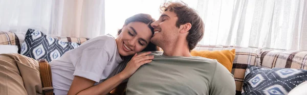 Brunette woman hugging smiling boyfriend on bed in camper van, banner — Stock Photo