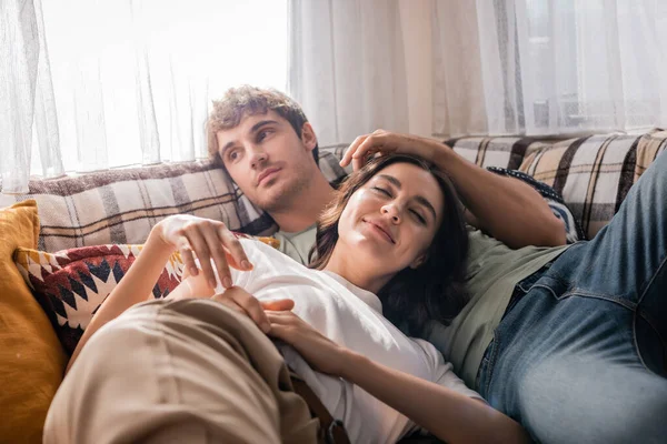 Young man touching hair of girlfriend on bed in camper van — Stock Photo