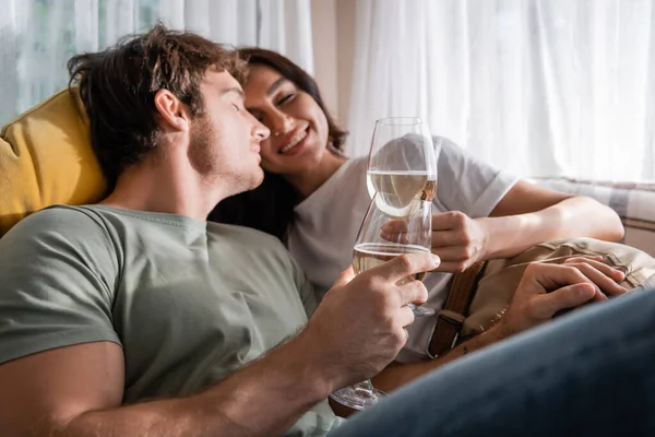 Positive couple holding wine and resting on bed in camper van — Stock Photo