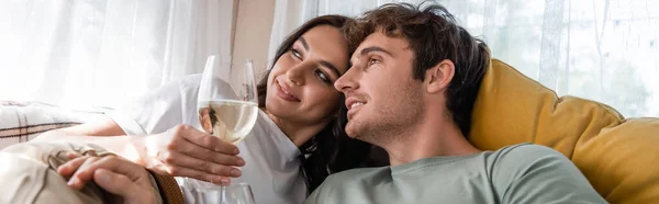 Молода пара тримає келихи вина на ліжку у фургоні, банер — стокове фото