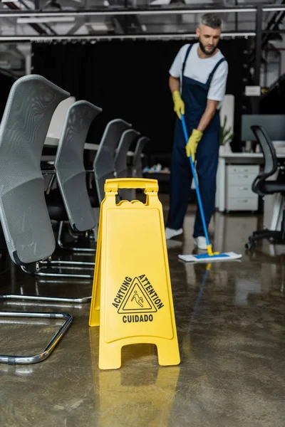 Selective focus of attention sign board near cleaner washing floor on blurred background — Stock Photo