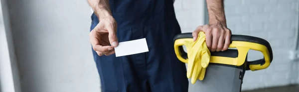 Partial view of man with blank business card near professional floor scrubber machine, banner — Stock Photo