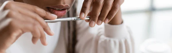 Vista cortada da mulher de negócios americana africana segurando caneta no escritório, bandeira — Fotografia de Stock