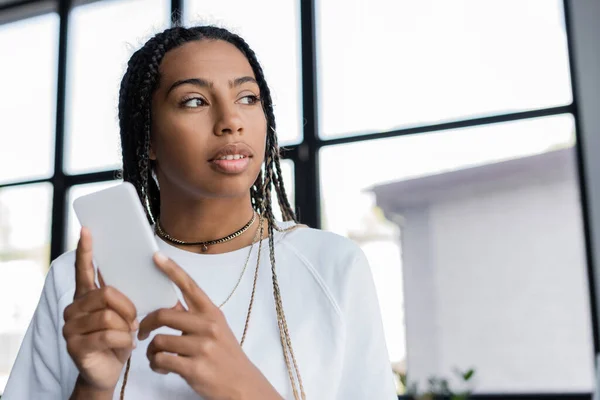 African american businessman holding cellphone in office — Stock Photo