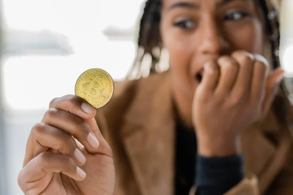 KYIV, UKRAINE - APRIL 27, 2022: Blurred african american businesswoman holding bitcoin — Stock Photo