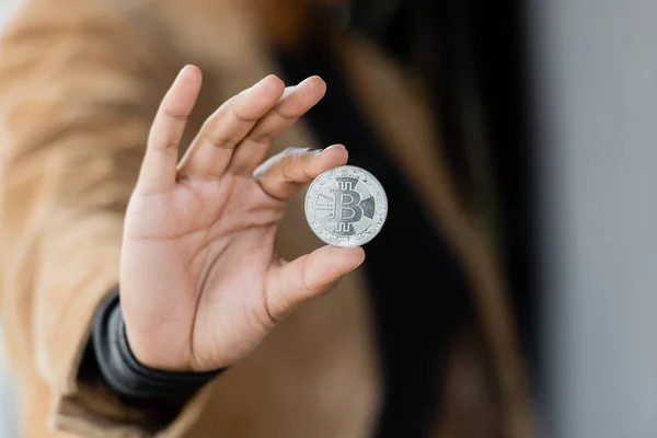 KYIV, UCRAINA - APRILE 27, 2022: Vista ritagliata di donna d'affari afro-americana in possesso di bitcoin d'argento — Foto stock
