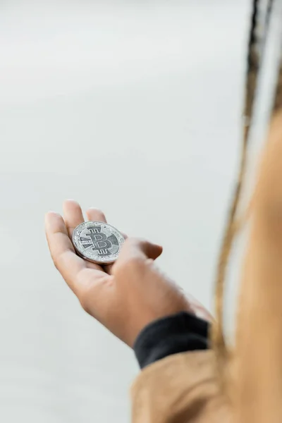 KYIV, UKRAINE - APRIL 27, 2022: Cropped view of bitcoin on hand of african american businesswoman — Stock Photo