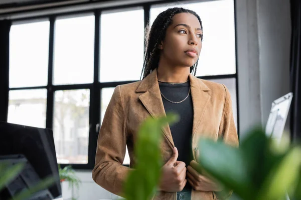 Femme d'affaires afro-américaine en veste regardant loin dans le bureau — Photo de stock