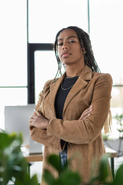 Donna d'affari afroamericana in giacca incrociando le braccia in ufficio — Foto stock