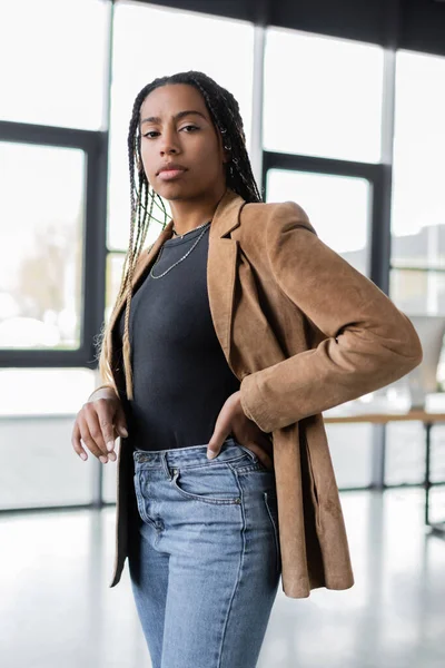 Donna d'affari afroamericana in giacca e jeans in piedi in ufficio — Foto stock